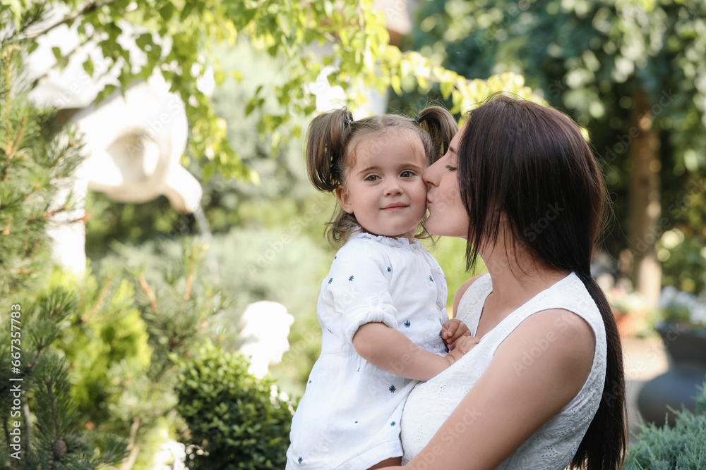 Happy mother with her cute daughter spending time together in park Happy mother with her cute daughter spending time together in park