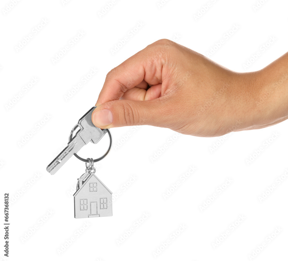 Woman holding key with metallic keychain in shape of house on white background, closeup Woman holding key with metallic keychain in shape of house on white background, closeup