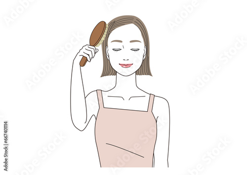 ヘアブラシで髪の毛をブラッシングしながら目を閉じている女性