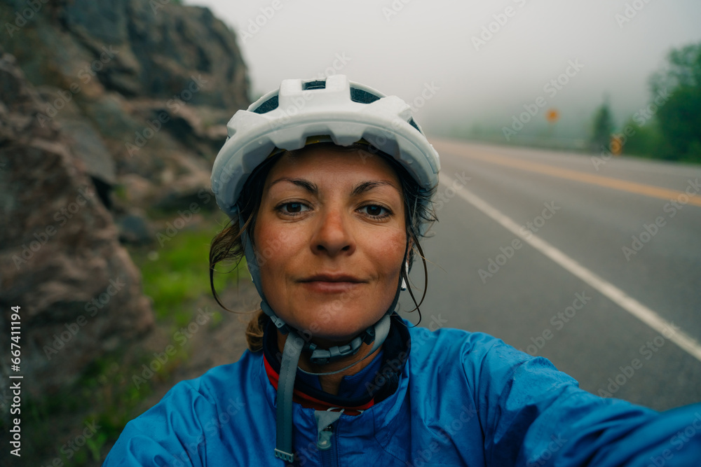 Bike helmet - woman putting biking helmet on outside during bicycle ride. Bike helmet - woman putting biking helmet on outside during bicycle ride.