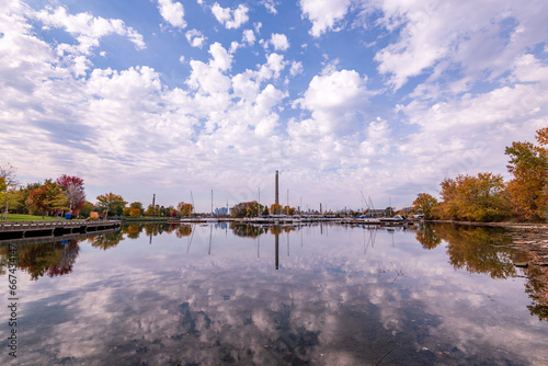 Photography blue sky and puffy white clouds reflected in the yacht basin at ashbridges bay i
