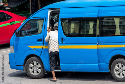 A man get out of the minivan - shared taxi, a traditional public transport of people in Thailand