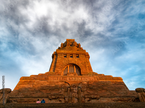 rotes Völkerschlacht-Dankmal Leipzig unter bewöltem Himmel bei Sonnenuntergang