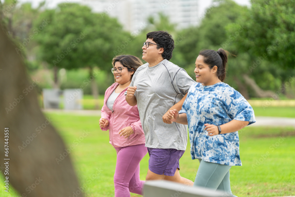 Overweight friends in sportive clothes running along a park Overweight friends in sportive clothes running along a park