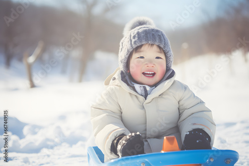 Happy little girl riding a sled on snow slides in winter, outdoor fun for family Christmas vacation