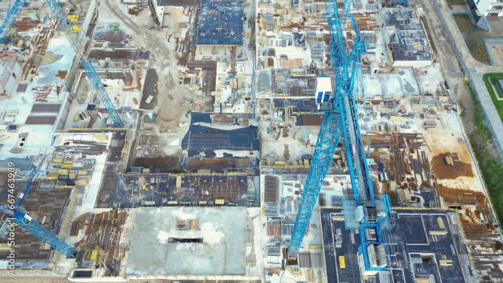 Aerial Bird Eye View Of a Construction Site Building Cranes Looking Down Industrial Machinery Area around Residential Urban Apartments