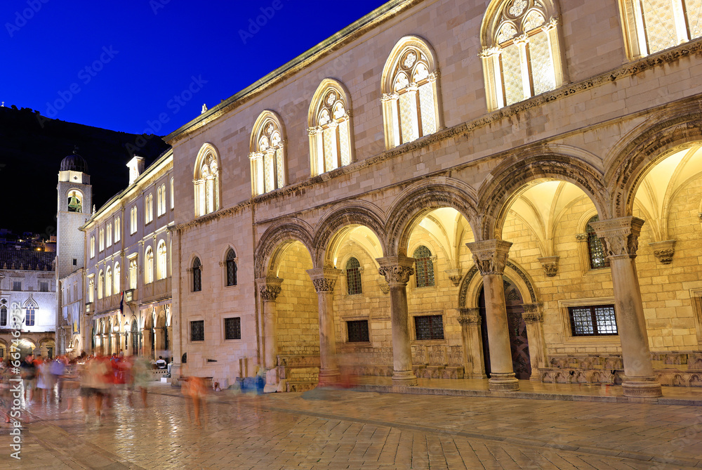Ancient street in Dubrovnik illuminated at dusk with Rector Palace on the foreground, Croatia