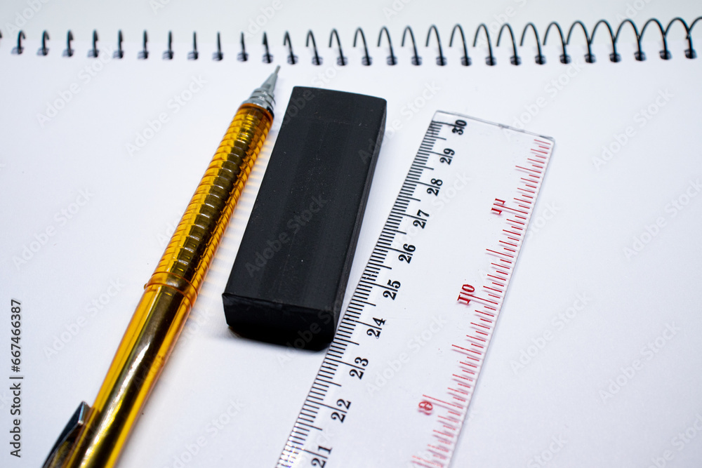 mechanical pencil, eraser and ruler on a sketchbook