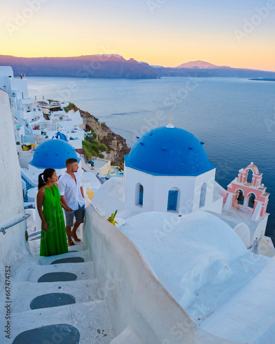 A couple of men and woman on vacation in Greece visited the village of Oia Santorini during sunset, a mature couple on a luxury holiday