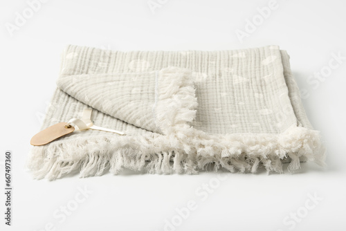 Fototapeta Naklejka Na Ścianę i Meble -  Warm cotton gray blanket with paper tag on white background
