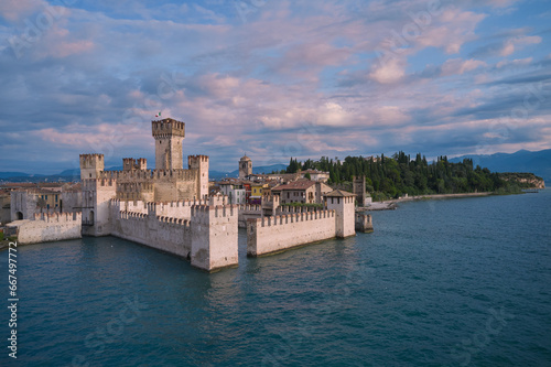 Scaliger Castle Sirmione on Lake Garda in Italy. Morning view of Scaliger Castle Sirmione. Pink clouds over Scaliger Castle. Sirmione at sunrise.