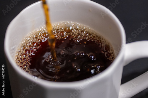 pouring coffee into a white porcelain cup