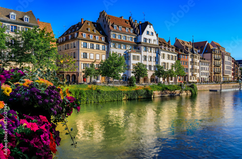 Ornate traditional half timbered houses with steep roofs above the Ill River with blooming flowers, the historic center of Strasbourg, Alsace, France © SvetlanaSF