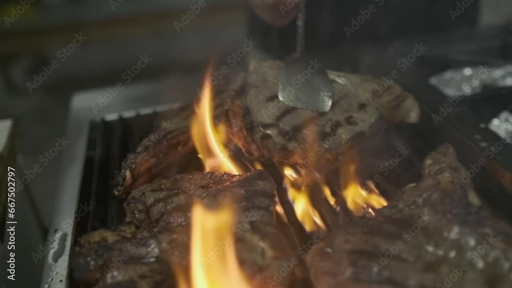 The chef touches and flips pieces of grilled meat steak The chef touches and flips pieces of grilled meat steak
