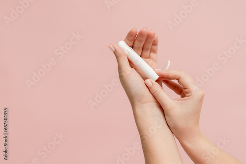 Medical feminine tampon in hand. Cotton swab. Menstruation photo