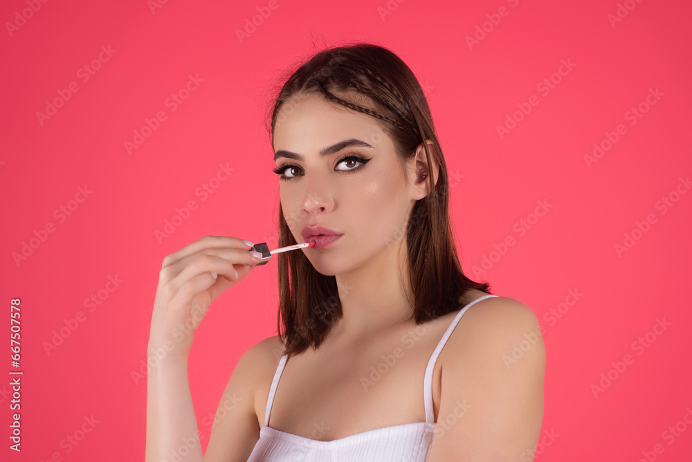 Beautiful young woman applying red lipstick on lips, studio color background. Sexy girl applied lipstick. Young nodel holding pink lipstick. Red lips make up. Beautiful woman putting lipstick on lips. Beautiful young woman applying red lipstick on lips, studio color background. Sexy girl applied lipstick. Young nodel holding pink lipstick. Red lips make up. Beautiful woman putting lipstick on lips.