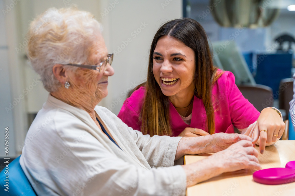 Woman and nurse playing board game in a nursing home Woman and nurse playing board game in a nursing home