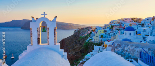 White churches an blue domes by the ocean of Oia Santorini Greece, a traditional Greek village in Santorini at sunset
