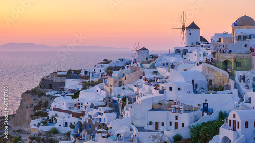 White churches an blue domes by the ocean of Oia Santorini Greece, a traditional Greek village in Santorini during summer at sunset