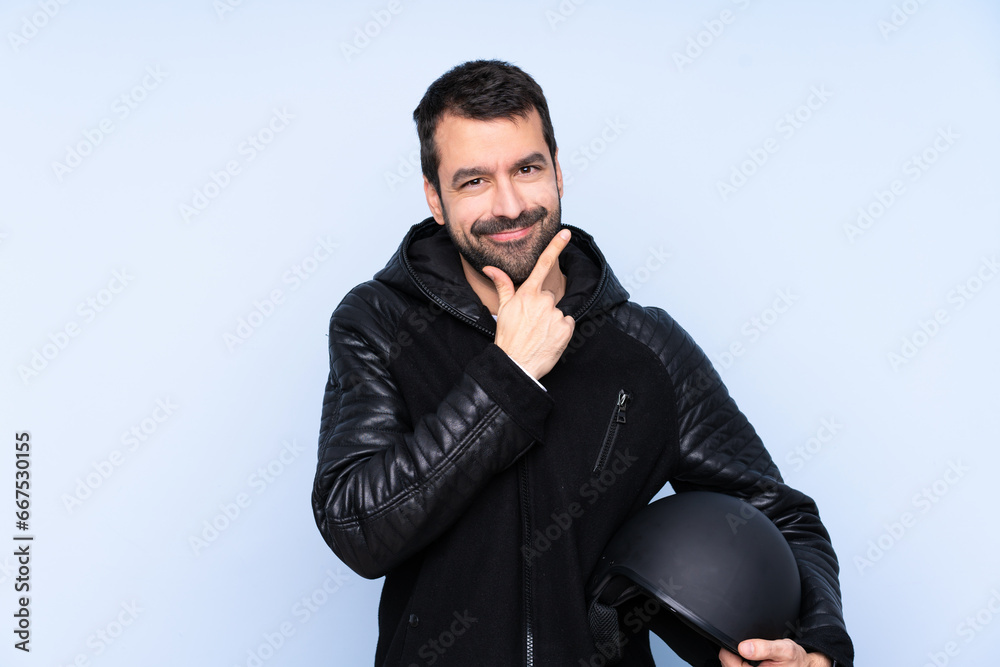 Fototapeta premium Man with a motorcycle helmet over isolated background smiling