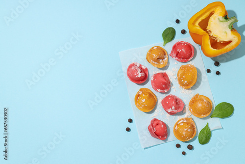 Colored dumplings and bell peppers on blue background, space for text