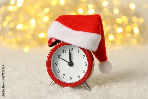 A clock with a Santa hat with a New Year's decoration.