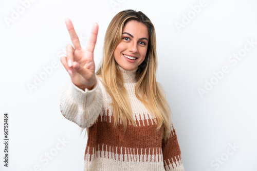 Young caucasian woman isolated on white background smiling and showing victory sign © luismolinero