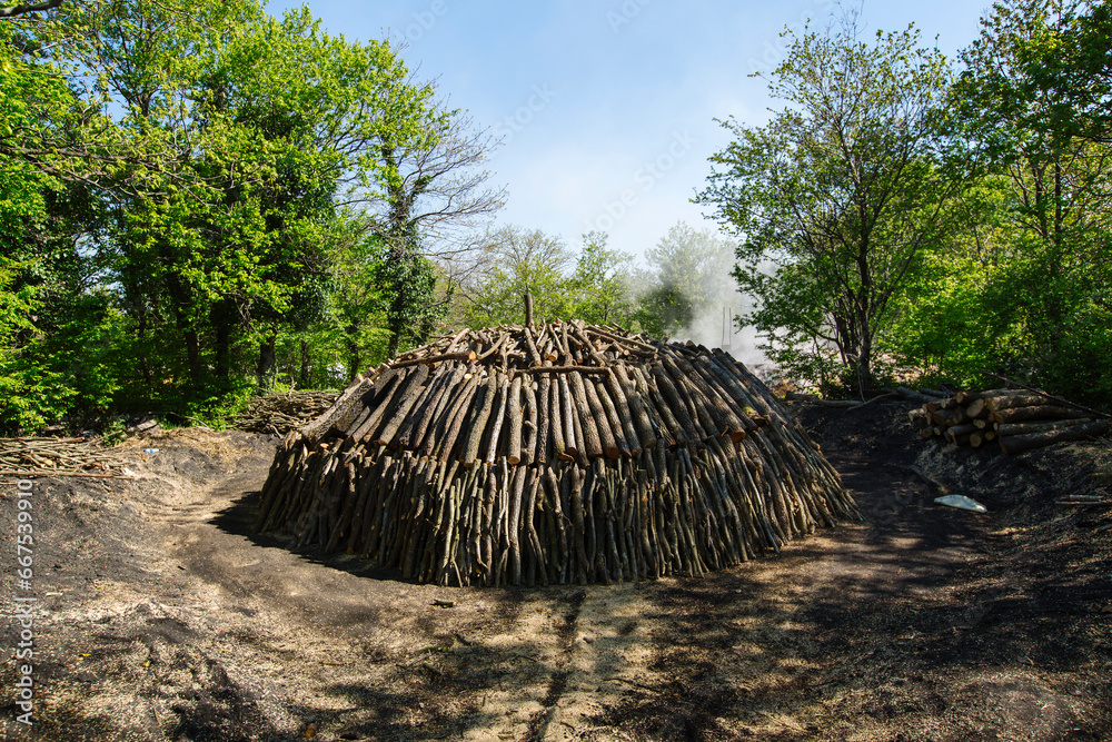Conical stacked Woodlogs for the manufacture of charcoal. Conical stacked Woodlogs for the manufacture of charcoal.