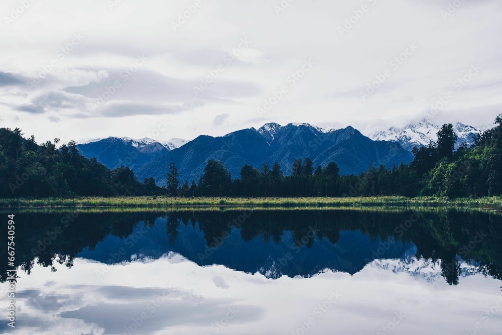 Tranquil and peaceful landscape of Mirror Lake in New Zealand surrounded by lush grass and trees