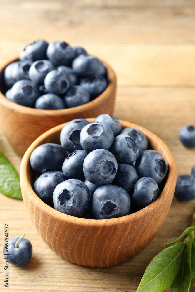 Bowls of fresh tasty blueberries on wooden table, closeup Bowls of fresh tasty blueberries on wooden table, closeup