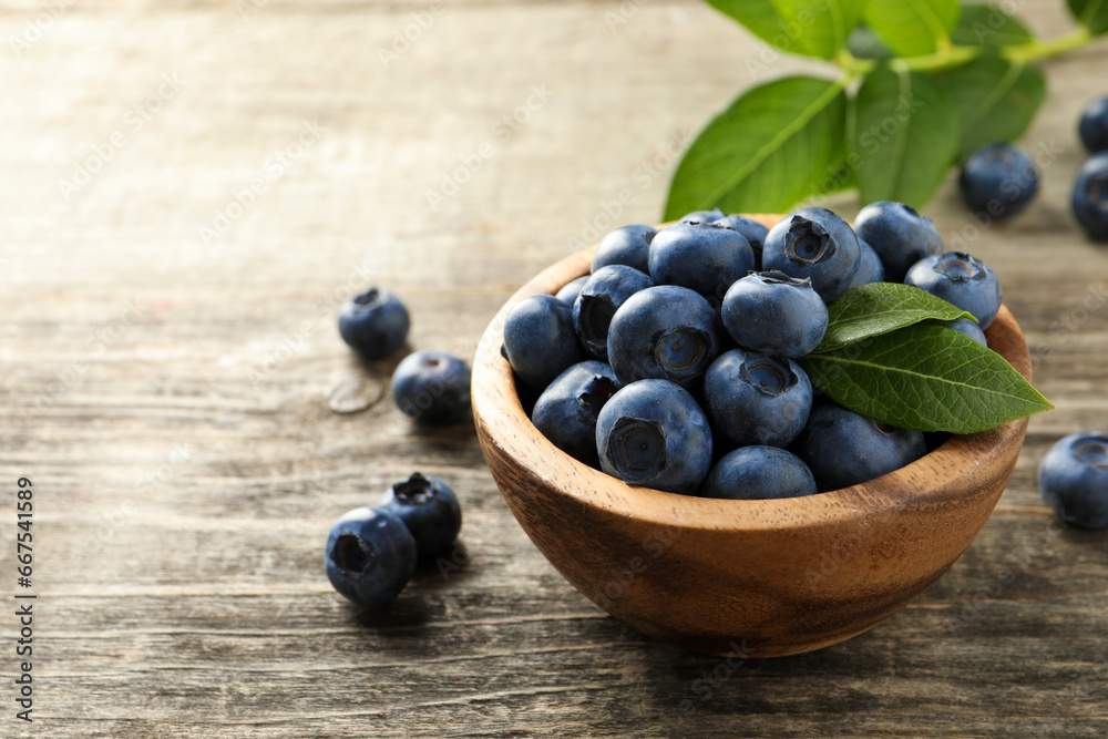 Bowl of fresh tasty blueberries on wooden table, space for text Bowl of fresh tasty blueberries on wooden table, space for text