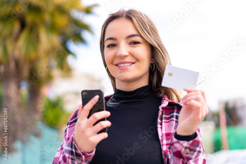 Young pretty Romanian woman at outdoors making a selfie with mobile phone