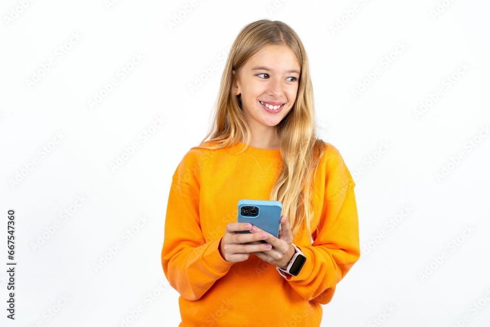 Beautiful teen blonde girl hold telephone hands read good youth news look empty space advert Beautiful teen blonde girl hold telephone hands read good youth news look empty space advert