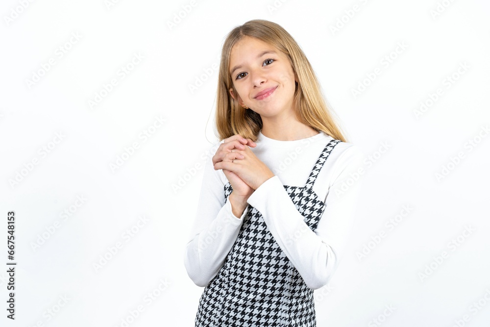 Charming serious Beautiful teen blonde girl keeps hands near face smiles tenderly at camera Charming serious Beautiful teen blonde girl keeps hands near face smiles tenderly at camera