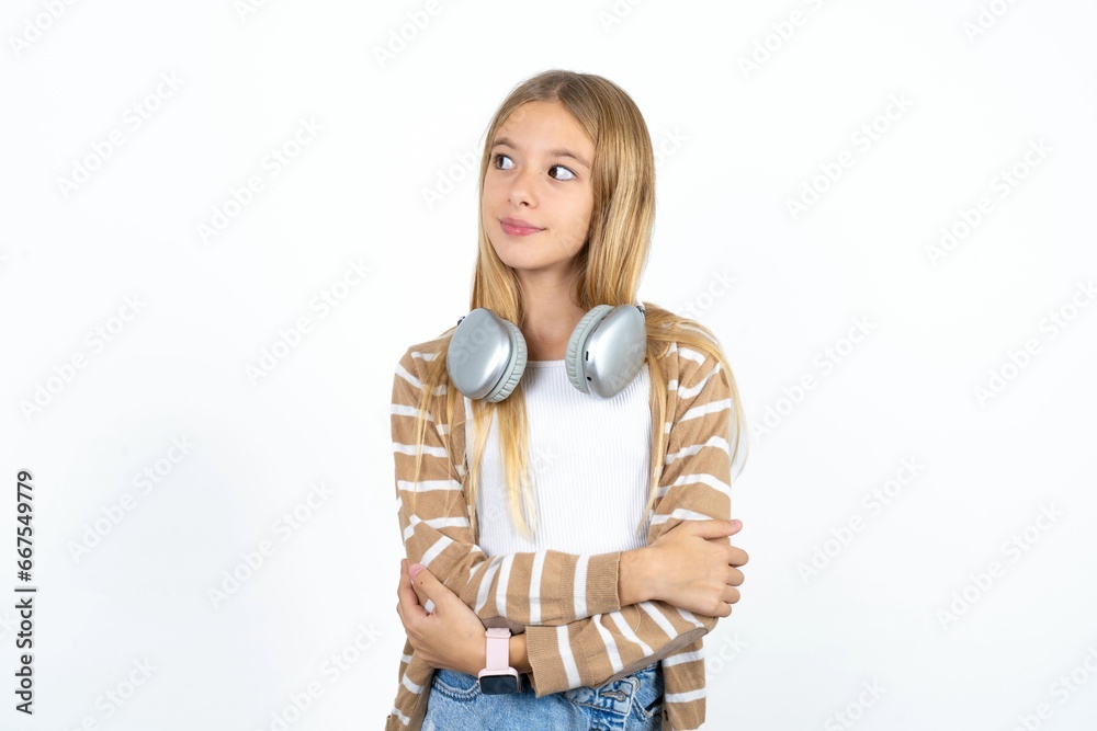 Pleased Beautiful teen girl keeps hands crossed over chest looks happily aside Pleased Beautiful teen girl keeps hands crossed over chest looks happily aside