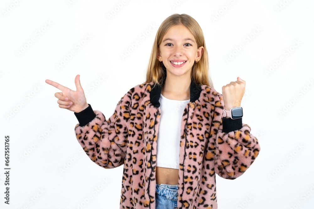 Beautifu blonde kid girl points at empty space holding fist up, winner gesture. Beautifu blonde kid girl points at empty space holding fist up, winner gesture.