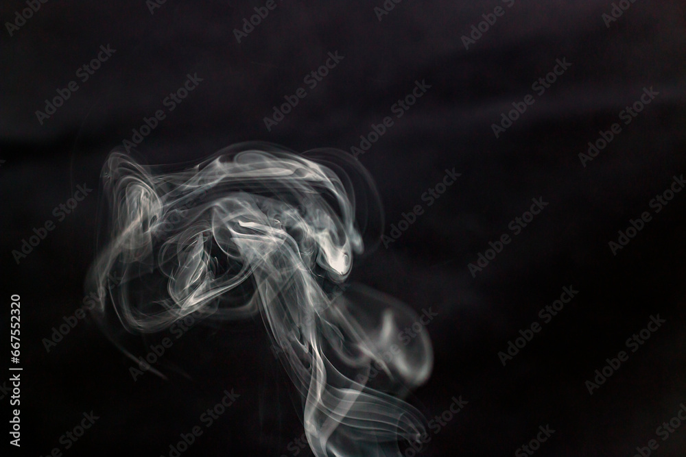 A lot of white smoke from incense flies beautifully in the air on a black background
A lot of white smoke from incense flies beautifully in the air on a black background