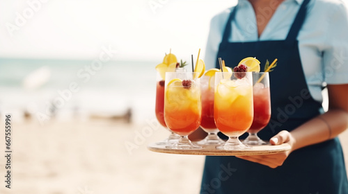 Young waitress with tray serving cocktail drinks photo