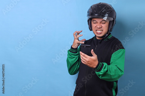 Asian online driver wear helmet and looking at smartphone with angry expression