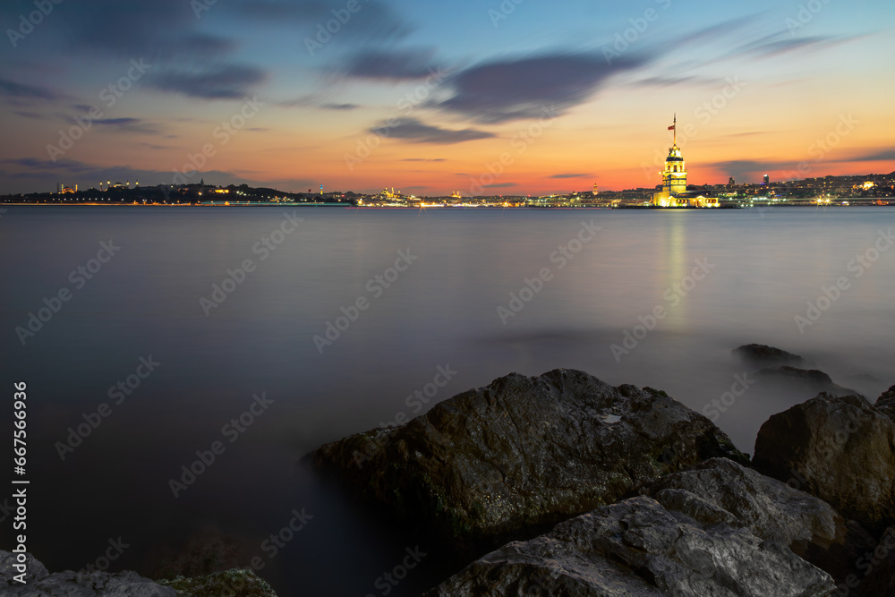 Illuminated Maiden Tower and Istanbul panorama at sunset, Turkey