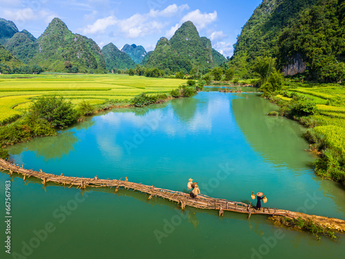 Aerial landscape in Phong Nam valley, farmers carry rice home at Cao Bang province, Vietnam with river, nature, green rice fields photo