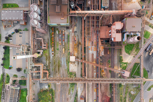 Steel factory from above. Birds-eye view of a bustling steel production unit, highlighting the crisscross of tracks and equ