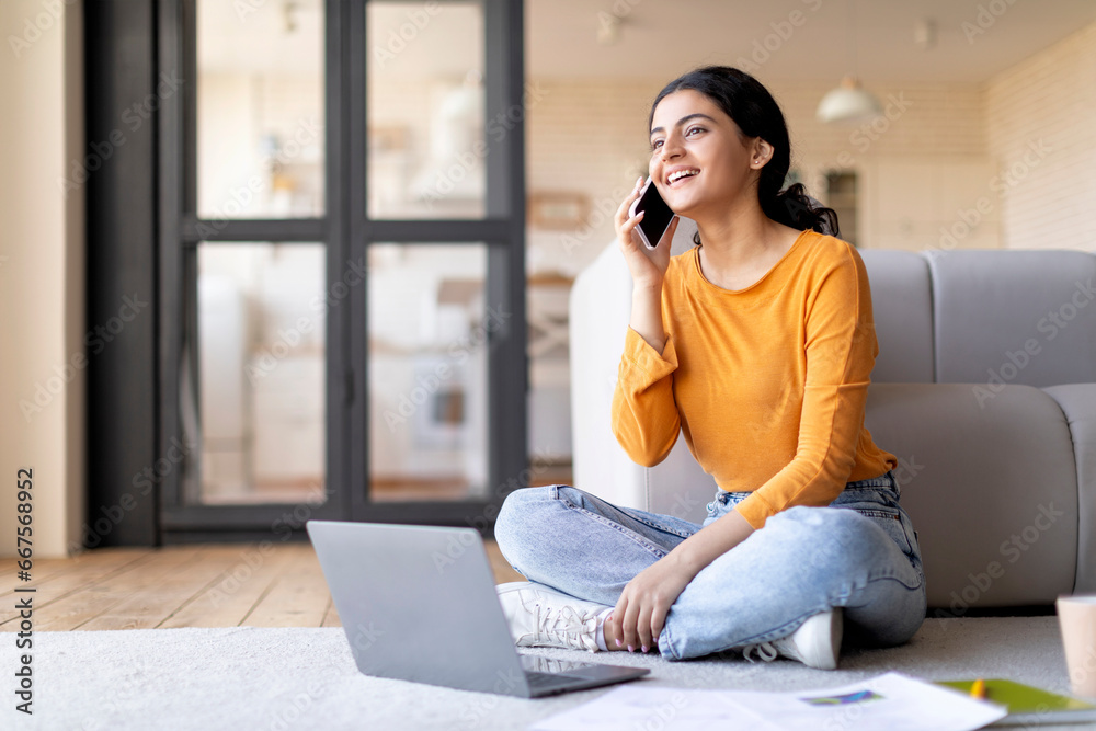 Mobile Communication. Indian Female Talking On Cellphone And Using Laptop At Home Mobile Communication. Indian Female Talking On Cellphone And Using Laptop At Home