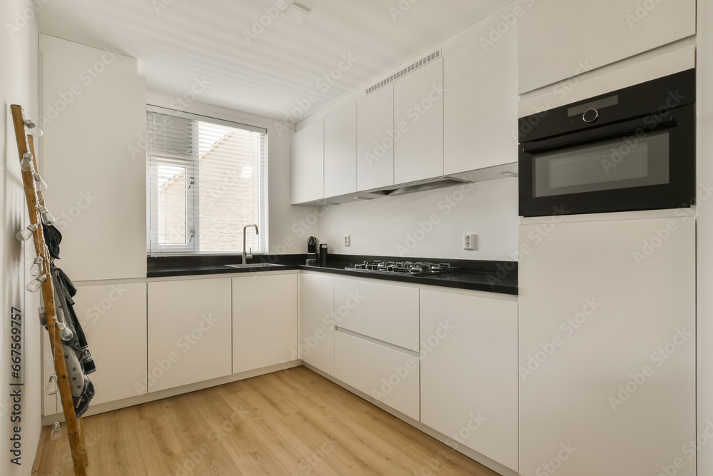 a kitchen with white cupboards and black counter tops on the counters in this photo is taken from the inside a kitchen with white cupboards and black counter tops on the counters in this photo is taken from the inside