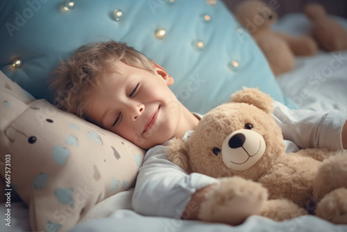 Little son with outstretched hands lying in bed with fluffy stuffed toys animal friends cat and teddy bear sleeping in cozy room. Kid girl covered with blanket enjoy healthy night sleep top view