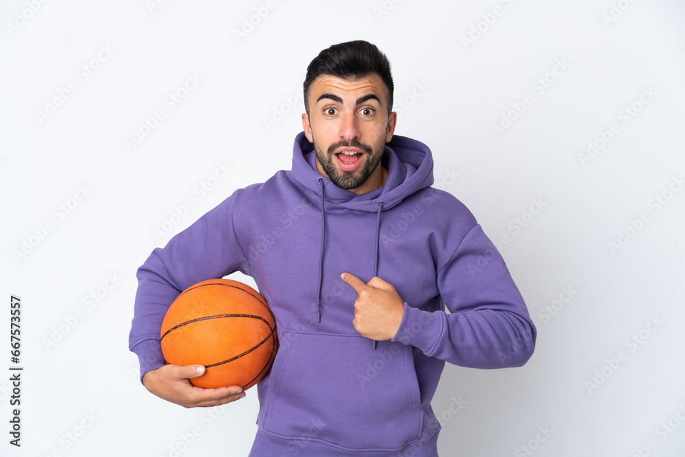 Man playing basketball over isolated white wall with surprise facial expression