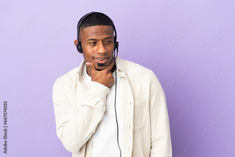 Telemarketer latin man working with a headset isolated on purple background looking to the side and smiling Telemarketer latin man working with a headset isolated on purple background looking to the side and smiling