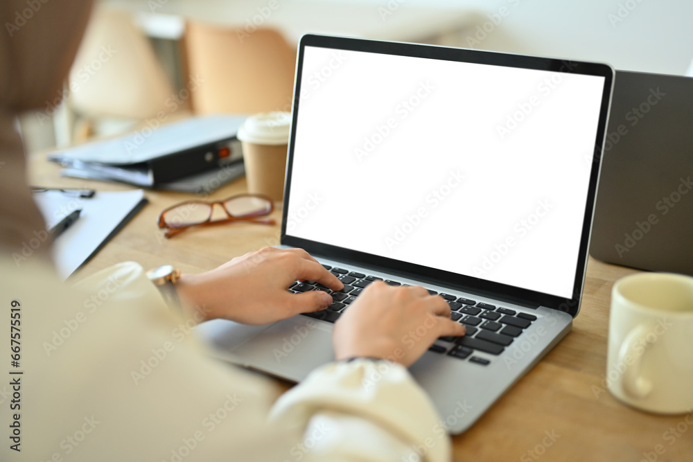 Over shoulder view of female employee hands typing on laptop. Business and technology concept Over shoulder view of female employee hands typing on laptop. Business and technology concept