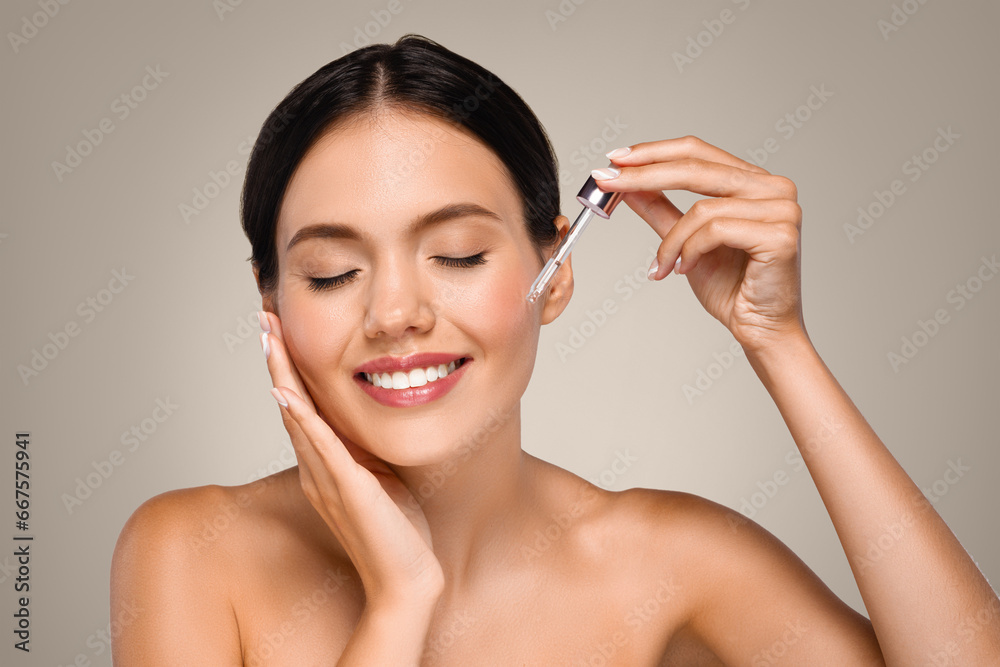 Cheerful young caucasian naked woman apply serum to skin face, enjoy spa treatments at home Cheerful young caucasian naked woman apply serum to skin face, enjoy spa treatments at home