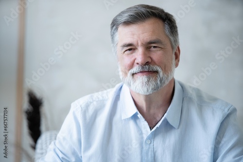Portrait of happy mature man sitting on sofa at home.